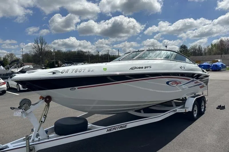 Slide: The Image of 2006 Custom 245 Boss boat on trailer under cloudy sky. - 32