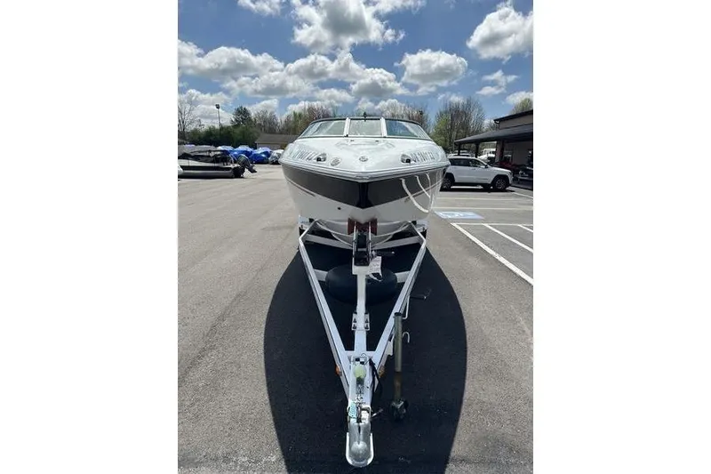 Slide: The Image of Custom 245 Boss 2006 boat on trailer under cloudy sky in parking lot. - 33