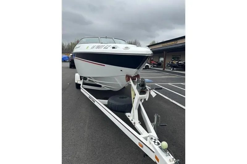 Slide: The Image of Custom 2006 245 Boss boat on trailer in parking lot, overcast sky. - 9