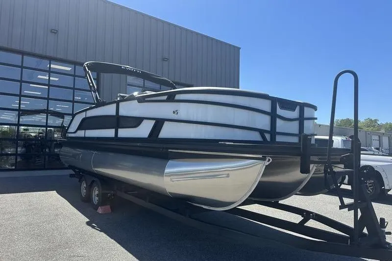 Slide: The Image of 2026 Evotti 523QL pontoon boat on trailer outside a modern building. - 7