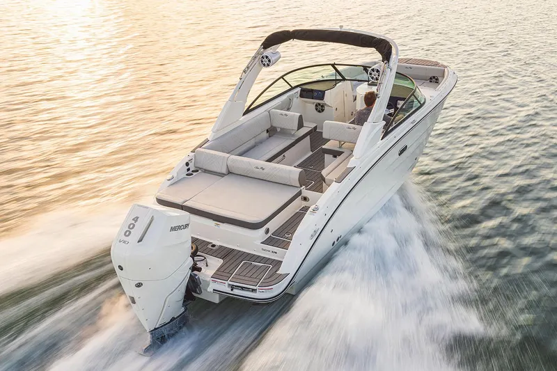 Slide: The Image of 2026 Sea Ray SDX 270 Outboard boat displayed outside a large warehouse. - 1
