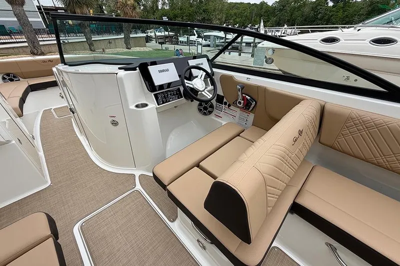 Slide: The Image of 2026 Sea Ray SDX 270 Outboard boat interior with beige seating and modern dashboard. - 20