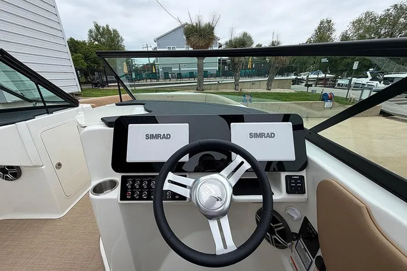 Slide: The Image of 2026 Sea Ray SDX 270 Outboard dashboard with dual Simrad displays and steering wheel. - 22