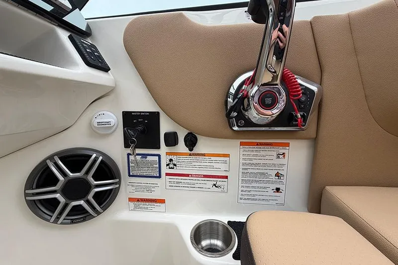 Slide: The Image of 2026 Sea Ray SDX 270 Outboard boat controls with speaker and warning labels. - 23