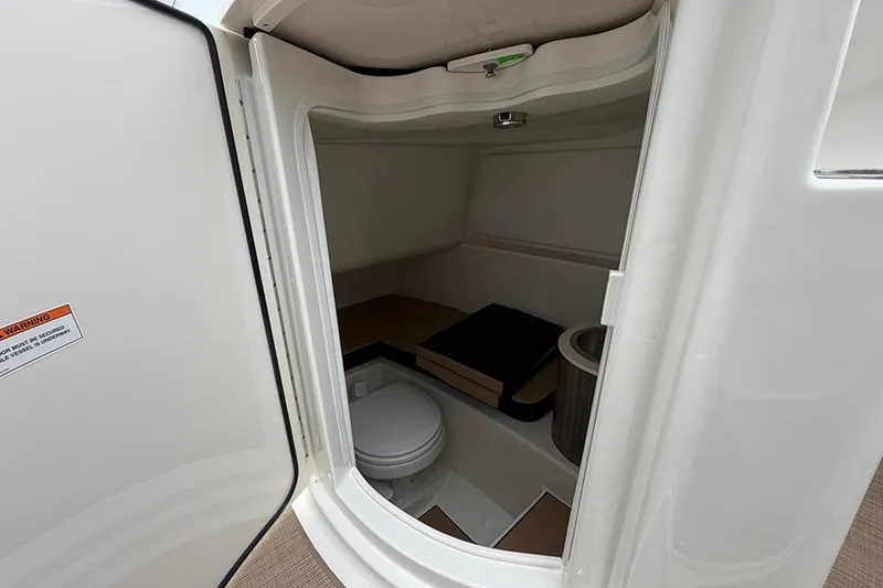 Slide: The Image of 2026 Sea Ray SDX 270 Outboard interior cabin with toilet and seating area. - 24