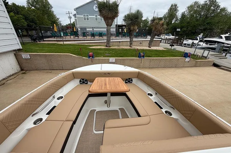 Slide: The Image of 2026 Sea Ray SDX 270 Outboard boat interior with tan seating and wooden table. - 31
