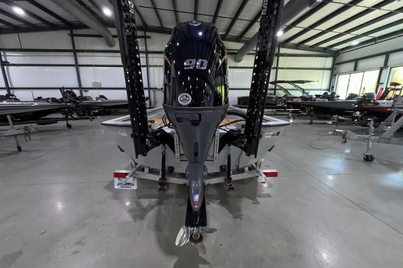 Slide: The Image of 2025 Avid 18 Rogue CC boat in showroom, rear view with motor and trailer. - 9