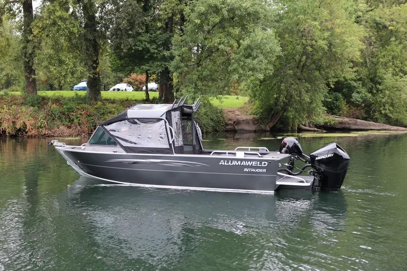 Slide: The Image of 2026 Alumaweld Intruder 22 boat on a serene lake with lush greenery. - 28