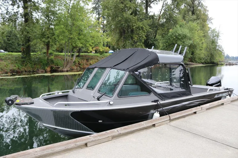 Slide: The Image of 2026 Alumaweld Intruder 22 boat docked on a serene river with lush greenery. - 31