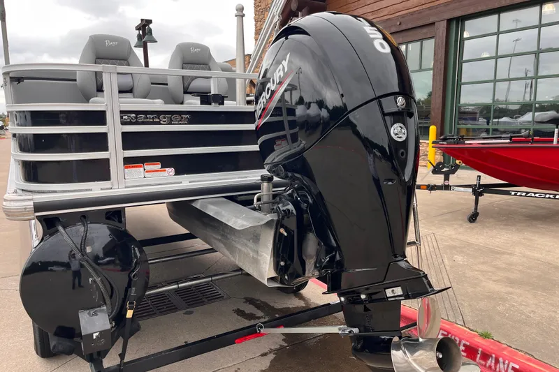 Slide: The Image of 2024 Ranger Reata 220FC pontoon boat with Mercury outboard motor, parked outdoors. - 12