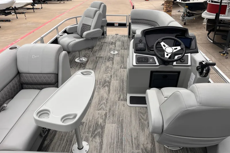 Slide: The Image of 2024 Ranger Reata 220FC pontoon boat interior with gray seating and modern dashboard. - 7