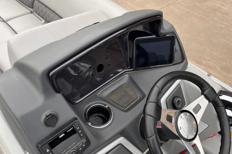 Slide: The Image of 2024 Ranger Reata 220FC boat dashboard with steering wheel and control panel. - 8