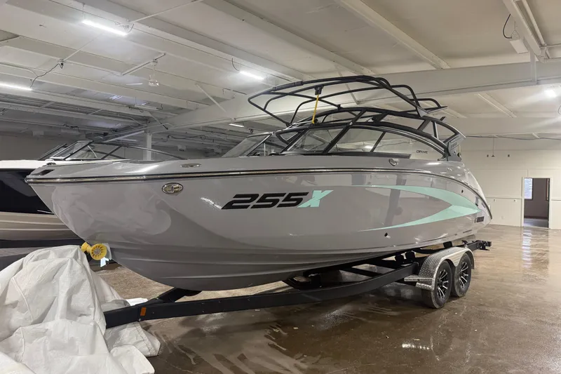 The Image of 2026 Yamaha Boats 255XD in showroom, sleek design, gray hull, on trailer. - 0