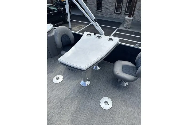Slide: The Image of 2022 Bennington LPD boat interior with table and swivel chairs. - 12