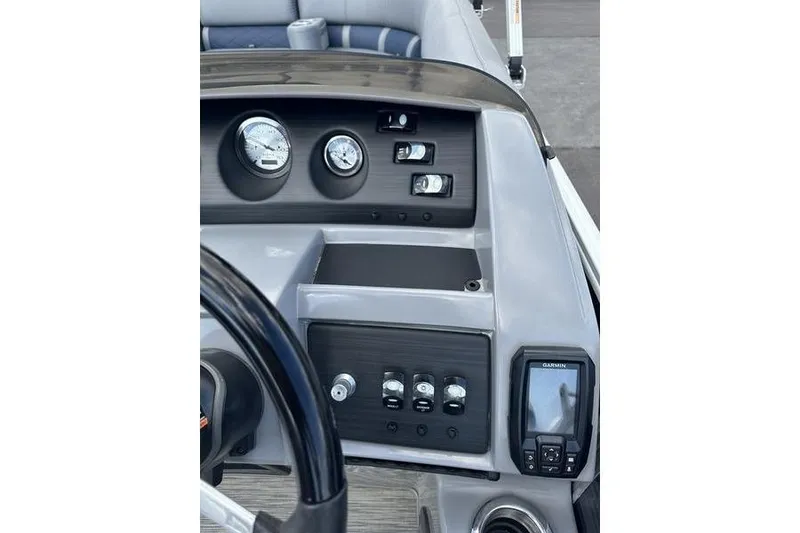 Slide: The Image of 2022 Bennington LPD pontoon boat on trailer at dealership under blue sky. - 7