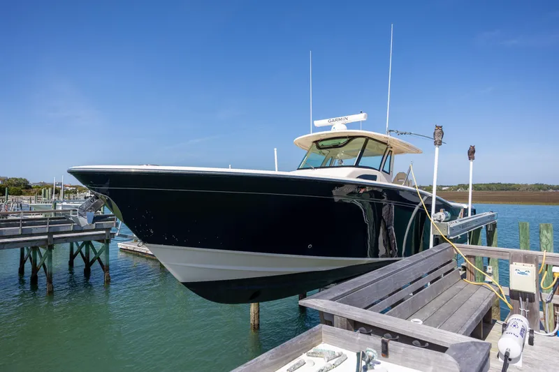 Slide: The Image of 2017 Grady-White Canyon 376 boat docked at marina under clear blue sky. - 13
