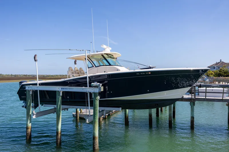 Slide: The Image of 2017 Grady-White Canyon 376 boat on lift, docked in clear blue water. - 14