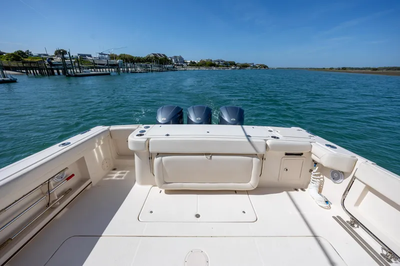 Slide: The Image of 2017 Grady-White Canyon 376 boat on calm water, showcasing spacious deck and twin engines. - 16