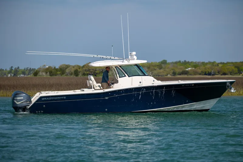 Slide: The Image of 2017 Grady-White Canyon 376 boat on water, side view, with Yamaha engines. - 2