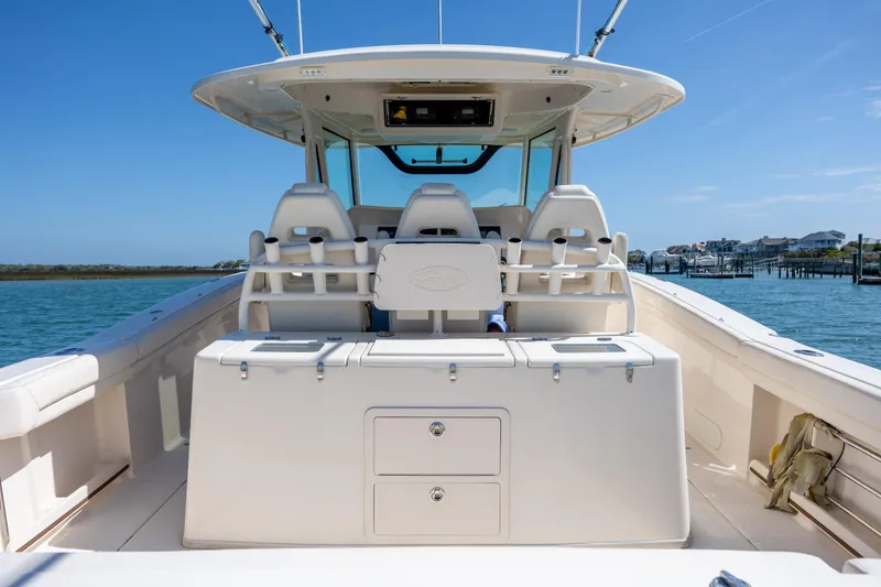 Slide: The Image of 2017 Grady-White Canyon 376 boat interior with seating and storage, docked by the water. - 22
