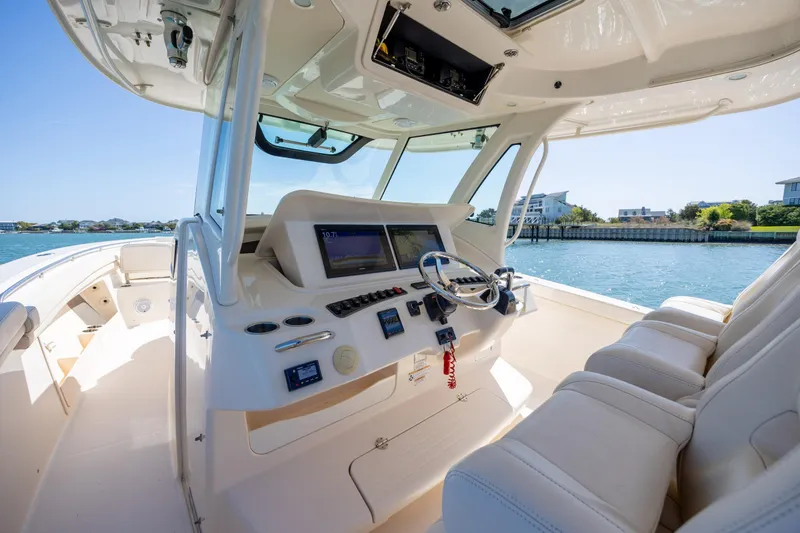 Slide: The Image of 2017 Grady-White Canyon 376 boat interior with helm, steering wheel, and navigation screens. - 26