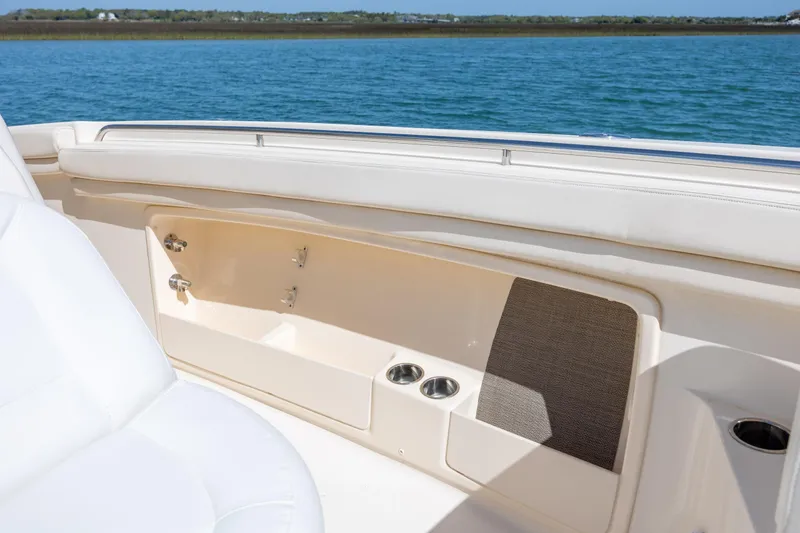 Slide: The Image of 2017 Grady-White Canyon 376 boat interior with seating and cup holders, overlooking calm waters. - 37