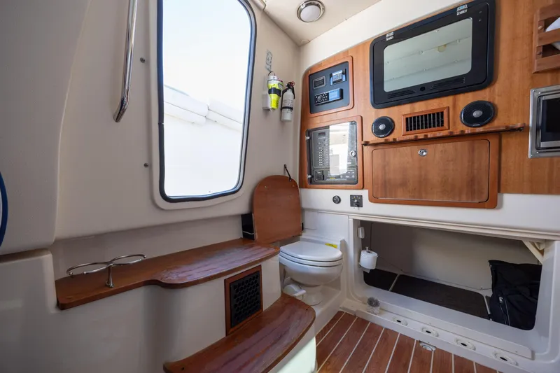 Slide: The Image of Interior of 2017 Grady-White Canyon 376 boat, featuring a compact bathroom and control panel. - 44