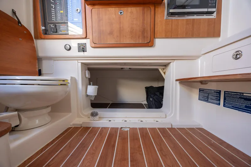 Slide: The Image of 2017 Grady-White Canyon 376 boat interior with wooden flooring and compact bathroom amenities. - 45