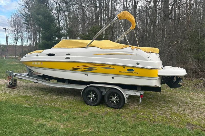 The Image of 2005 Chaparral Sunesta 216 boat with yellow accents on a trailer, parked outdoors. - 0