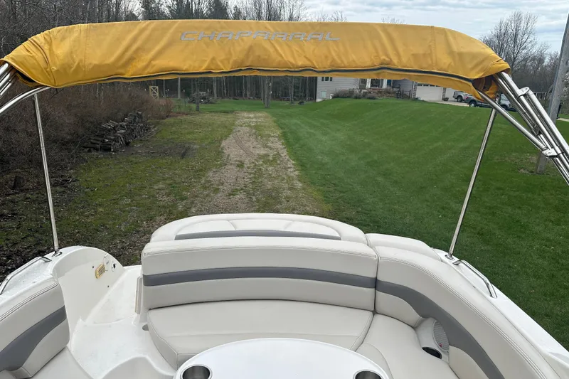 Slide: The Image of 2005 Chaparral Sunesta 216 boat with yellow canopy and white seating, parked on grass. - 21