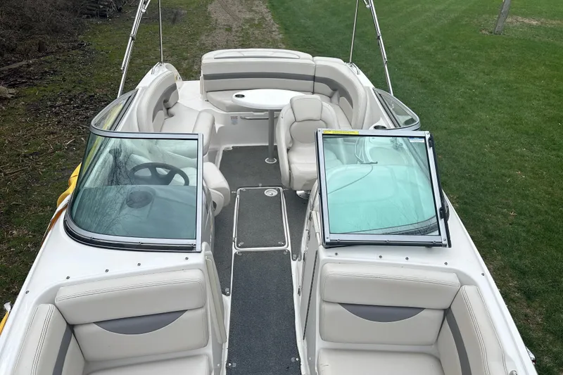 Slide: The Image of 2005 Chaparral Sunesta 216 boat interior with seating and windshield, parked on grass. - 5