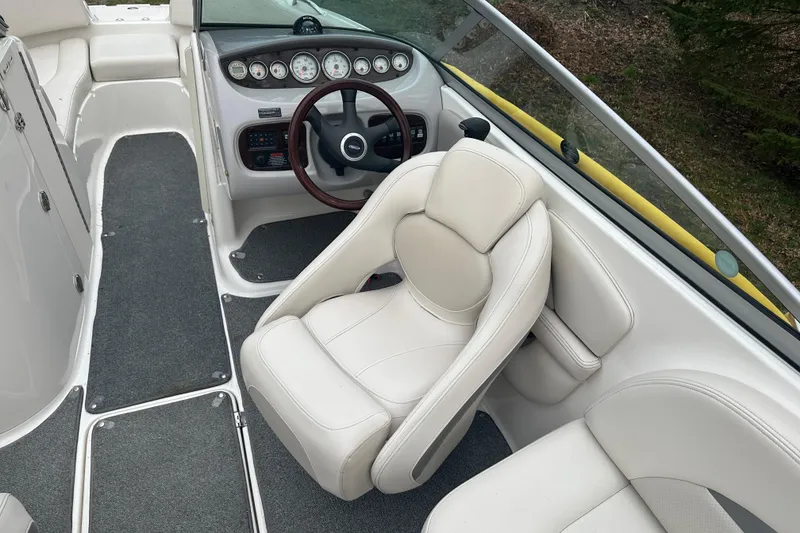Slide: The Image of Interior of a 2005 Chaparral Sunesta 216 boat, featuring white seating and dashboard controls. - 8