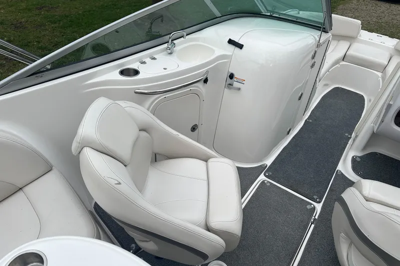 Slide: The Image of 2005 Chaparral Sunesta 216 boat interior with white seating and carpeted flooring. - 9