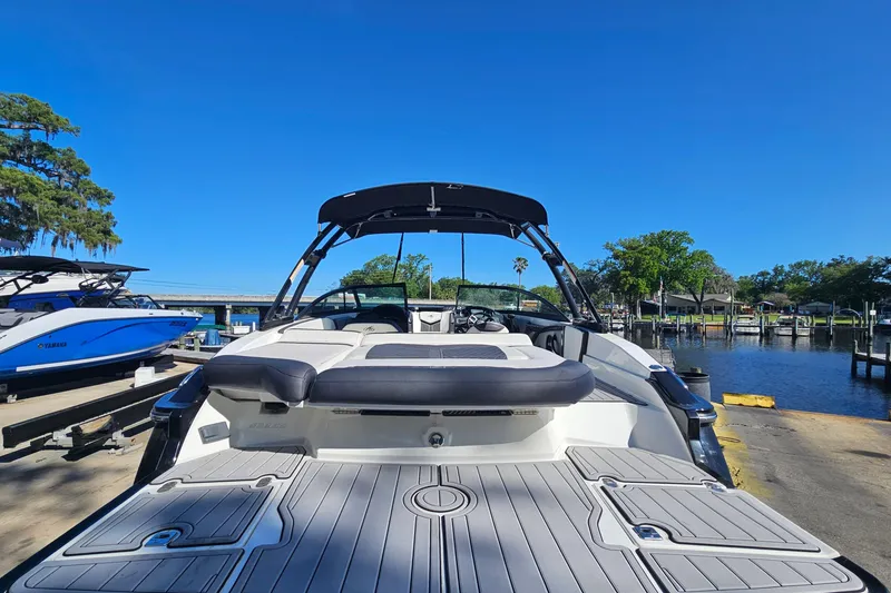 Slide: The Image of 2017 Monterey 238SS Super Sport boat docked by a serene waterfront. - 5