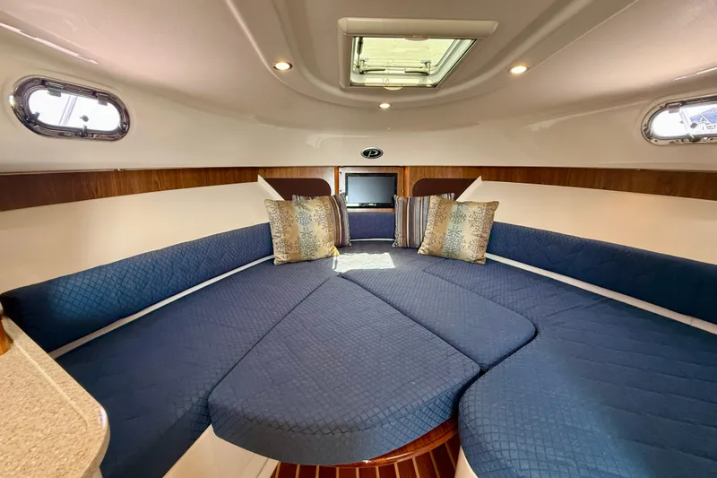 Slide: The Image of Interior of 2012 Pursuit OS 345 Offshore boat with blue seating and decorative pillows. - 11