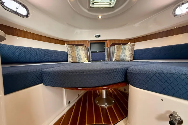 Slide: The Image of Interior of 2012 Pursuit OS 345 Offshore boat with blue seating and decorative pillows. - 12