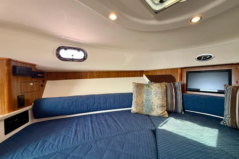 Slide: The Image of Interior cabin of 2012 Pursuit OS 345 Offshore with blue seating and decorative pillows. - 13