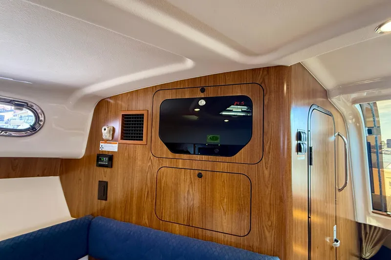 Slide: The Image of Interior cabin of a 2012 Pursuit OS 345 Offshore boat with wood paneling and seating. - 14