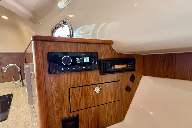 Slide: The Image of Interior of 2012 Pursuit OS 345 Offshore boat with wood paneling and audio system. - 18