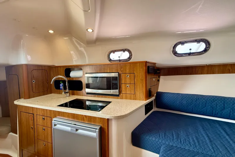 Slide: The Image of 2012 Pursuit OS 345 Offshore yacht interior with kitchenette and seating area. - 20