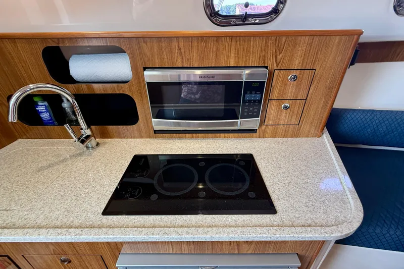 Slide: The Image of Compact kitchen in 2012 Pursuit OS 345 Offshore boat with microwave and stovetop. - 23