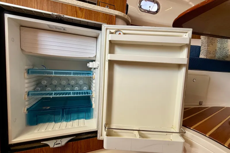 Slide: The Image of Refrigerator inside 2012 Pursuit OS 345 Offshore boat, stocked with water bottles. - 25