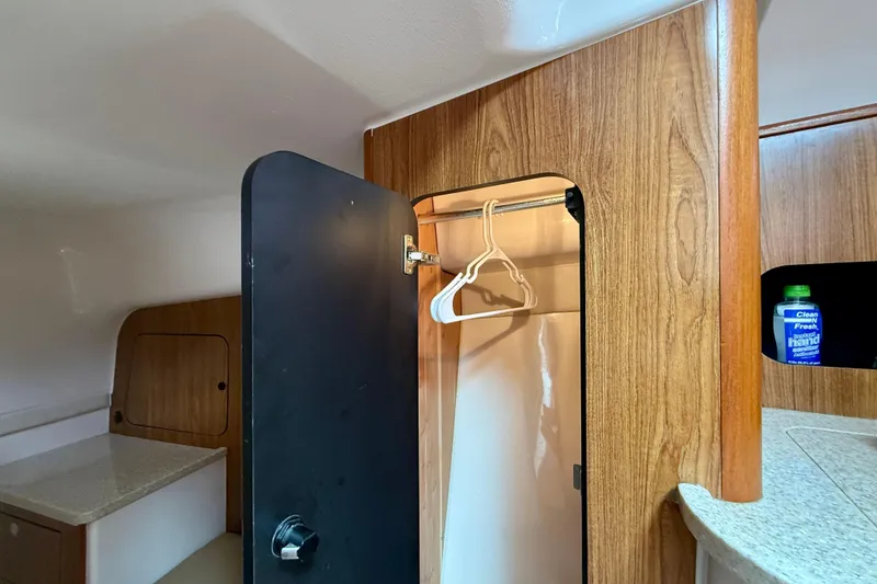 Slide: The Image of Interior of 2012 Pursuit OS 345 Offshore boat with wooden cabinetry and closet space. - 27
