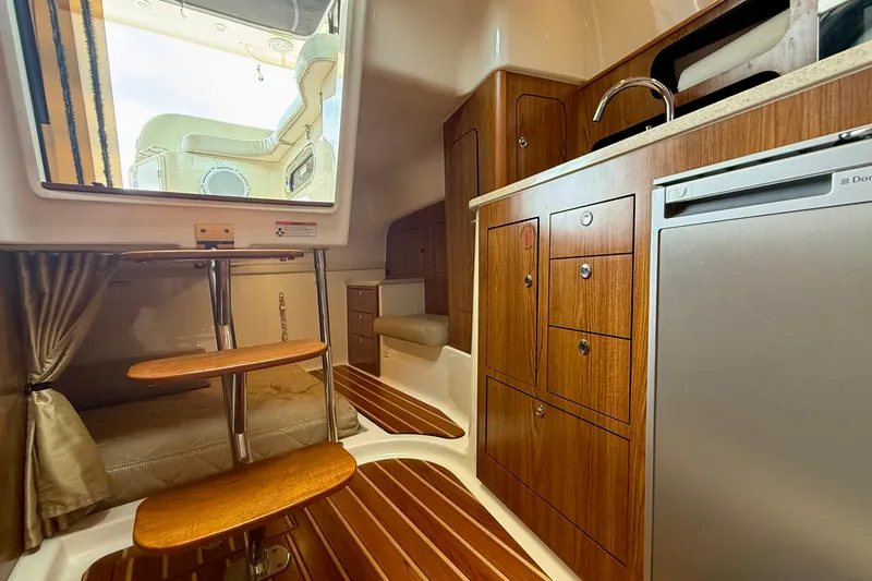 Slide: The Image of Interior of 2012 Pursuit OS 345 Offshore boat with wood cabinetry and compact kitchen area. - 28
