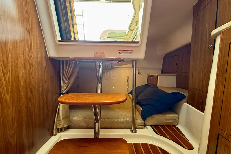 Slide: The Image of Interior cabin of 2012 Pursuit OS 345 Offshore boat with wooden accents and cozy seating. - 29
