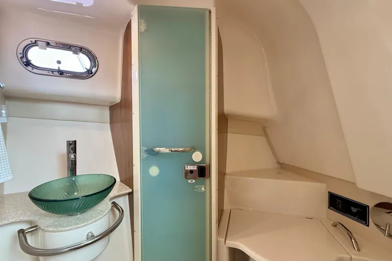 Slide: The Image of 2012 Pursuit OS 345 Offshore boat bathroom with glass sink and frosted door. - 34