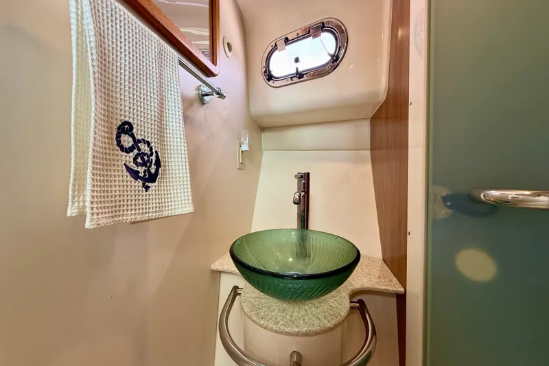 Slide: The Image of Luxurious bathroom in 2012 Pursuit OS 345 Offshore boat with glass sink and nautical decor. - 36