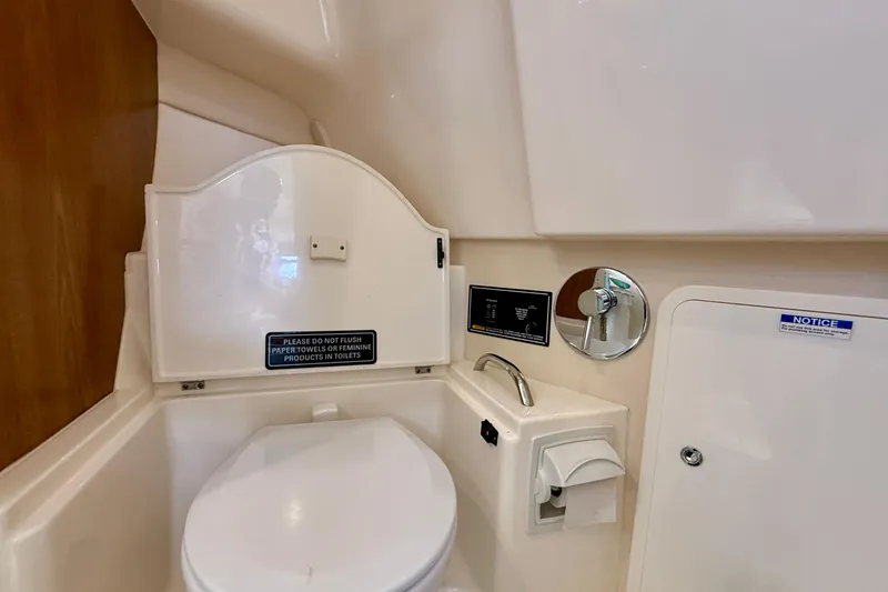 Slide: The Image of 2012 Pursuit OS 345 Offshore boat bathroom with toilet and warning signs. - 38