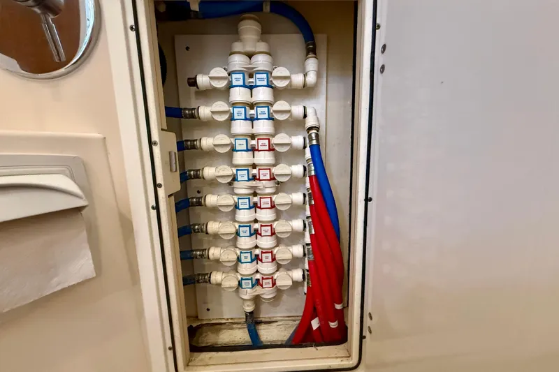 Slide: The Image of Plumbing system inside a 2012 Pursuit OS 345 Offshore boat, featuring labeled valves and colored pipes. - 39