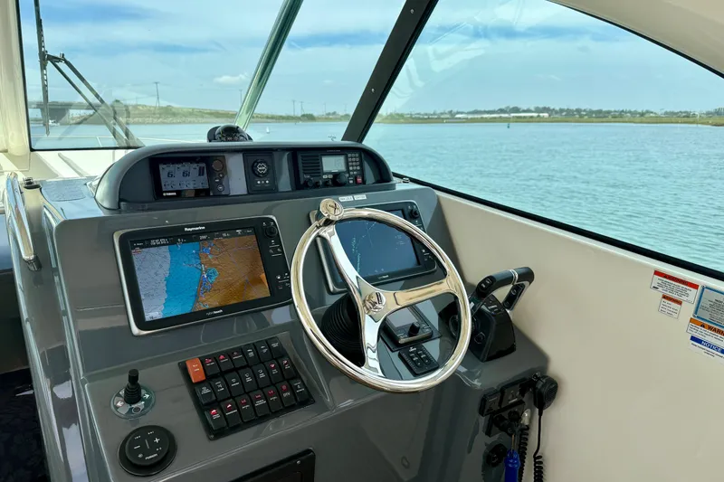 Slide: The Image of Helm of 2012 Pursuit OS 345 Offshore boat with navigation screens and steering wheel. - 41